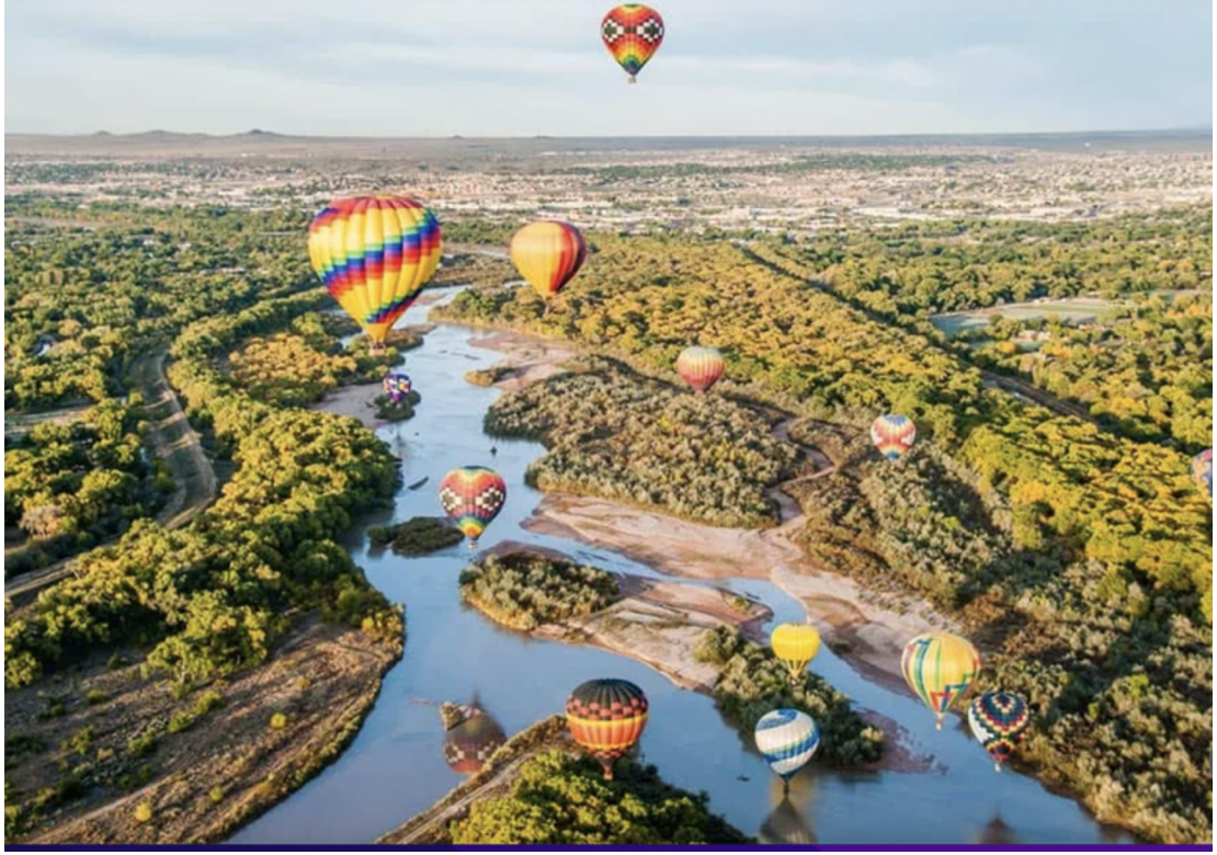 A group of hot air balloons over a river  Description automatically generated with medium confidence